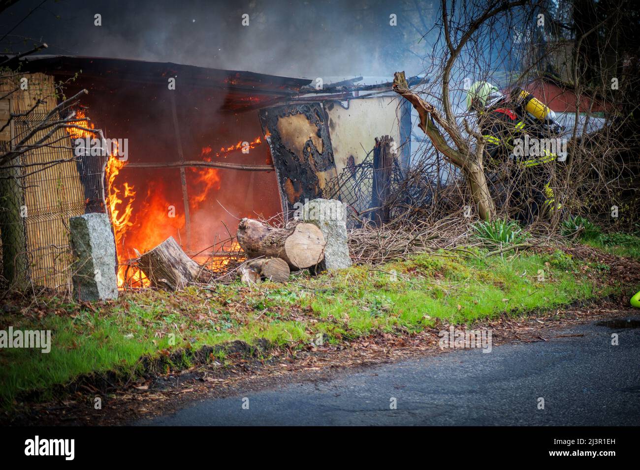 the fire department extinguishes a garden house that has caught fire ...