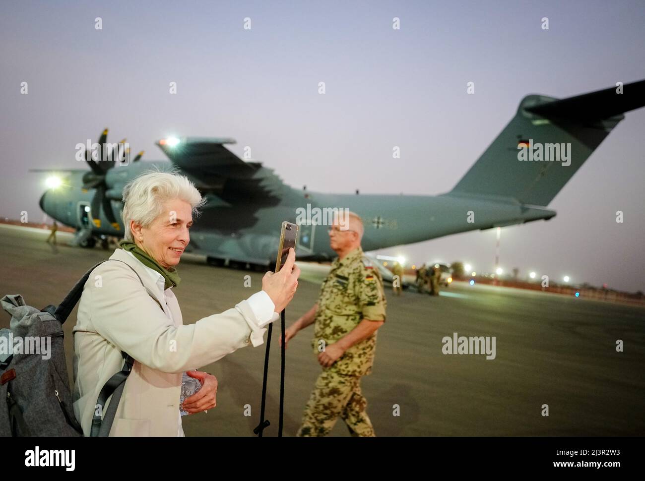 Niamey, Niger. 09th Apr, 2022. Marie-Agnes Strack-Zimmermann (FDP), chairwoman of the Defense Committee, takes a photo with her smartphone in the evening, after landing from Gao in Mali, in front of the Air Force Airbus A400M at Niamey airport. She is accompanying the defense minister on a visit by German soldiers to West Africa. The Bundeswehr is involved in Niger in the UN mission Minusma and the EU training mission EUTM. Credit: Kay Nietfeld/dpa/Alamy Live News Stock Photo