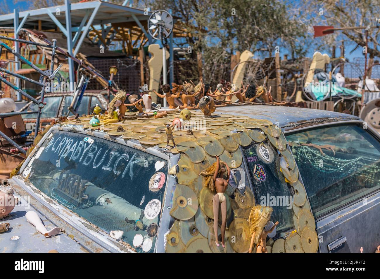 'Cry Baby Buick' is an art installation on an old Buick car covered with Barbie dolls, CDs, and miscellaneous stuff in the off the grid settlement of Stock Photo