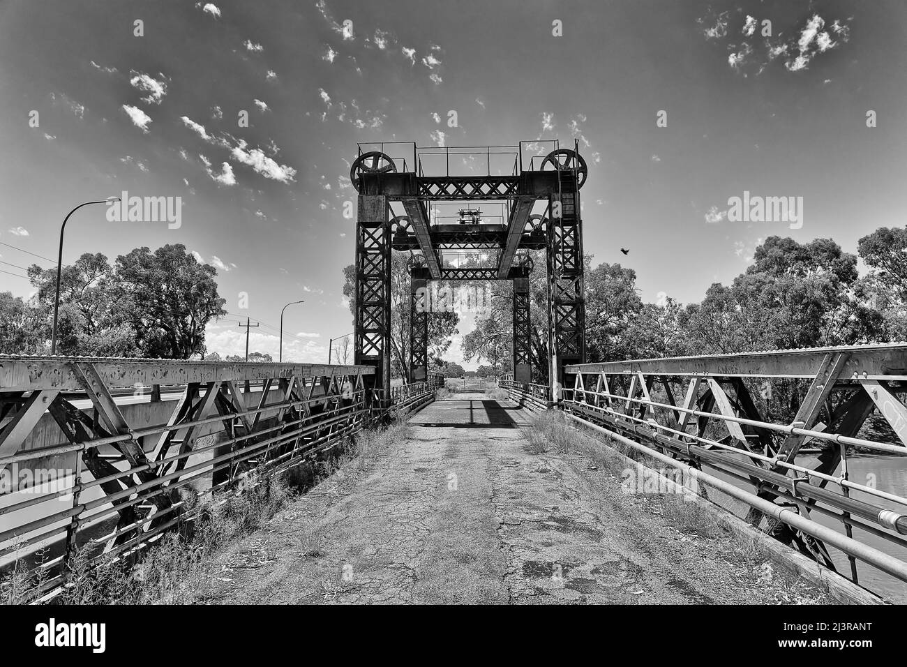 Moody contrast black white impression of Historic steel spit bridge across Darling river in Wilcannia town of Australian outback. Stock Photo