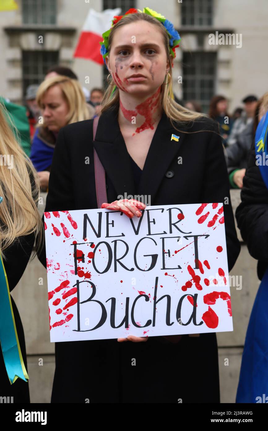 London, England, UK 9 April 2022 Stand with Ukraine protest and die-in at Downing Street. Protesters wore traditional costumes and carried placards with statements concerning crimes committed by Russian soldiers and lay with hands tied and chained. Stock Photo