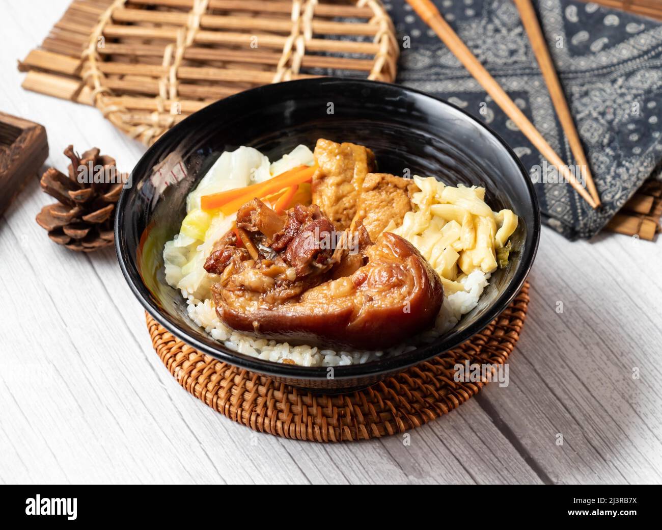 Pork Knuckle rice Bento in a dish isolated on wood table side view