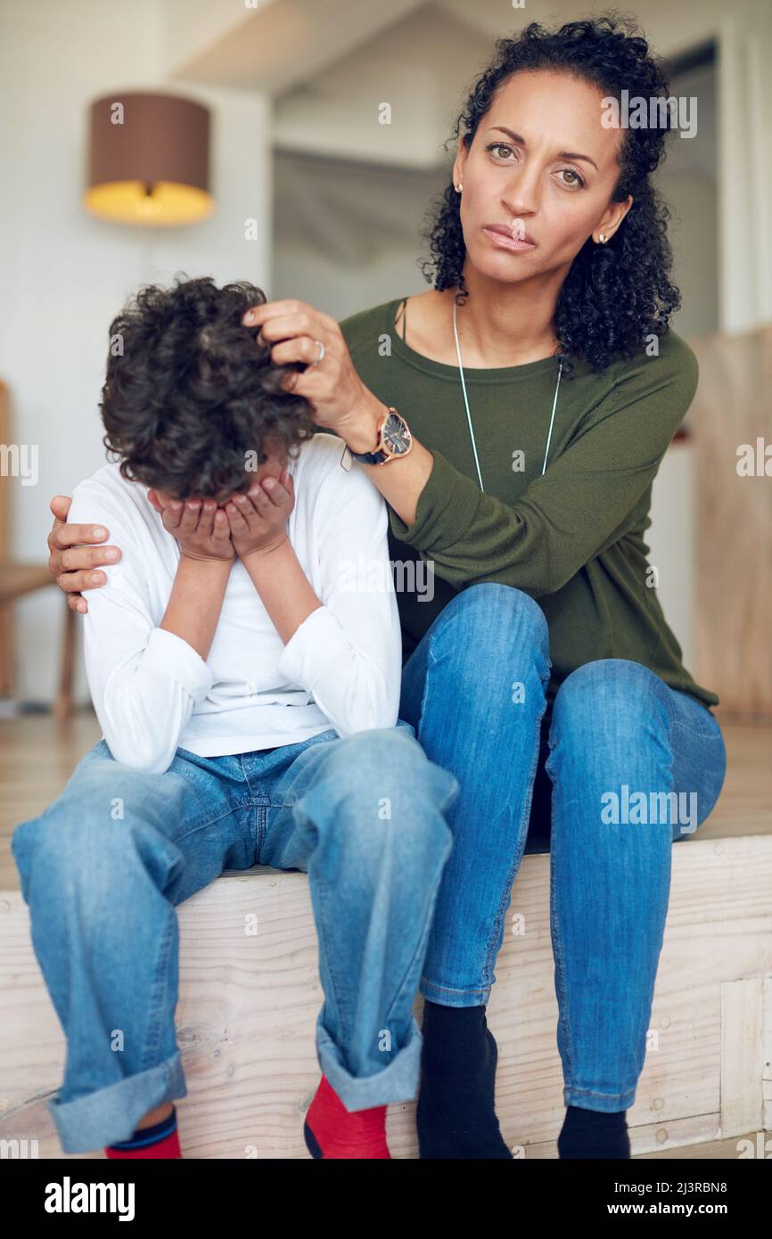 Ive been trying so hard to cheer him up. Portrait of a mother comforting her little son at home. Stock Photo