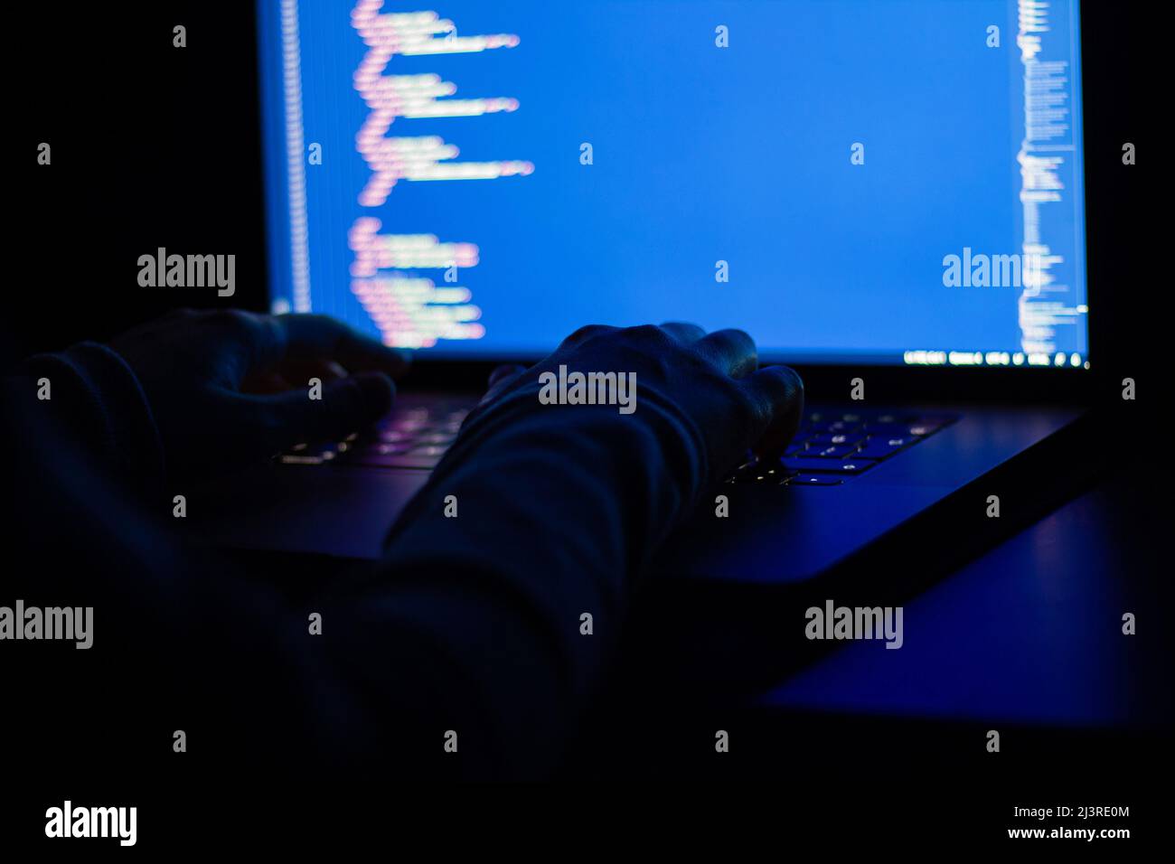 Freelance web developer working at night, programming the web with javascript like a hacker. Close-up hand and computer Stock Photo