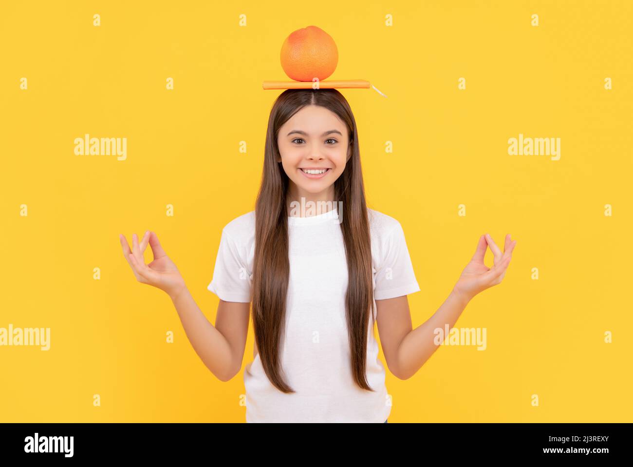 happy kid hold grapefruit and book on yellow background, vitamin Stock Photo