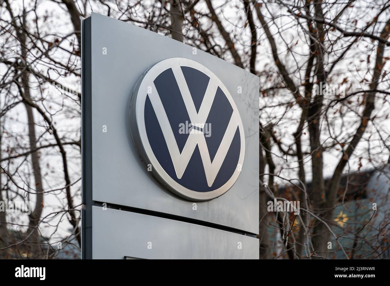 New Volkswagen AG logo. VW emblem on a grey background standing around. Marketing of the automotive industry in Germany. Logo rebranding of VW in 2019 Stock Photo