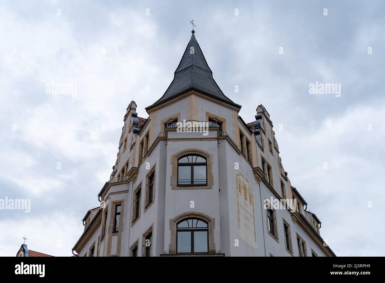 Old building on a street corner in the inner city. Beautiful facade with ancient architecture. Exterior of a residential house. Viewing to the rooftop Stock Photo