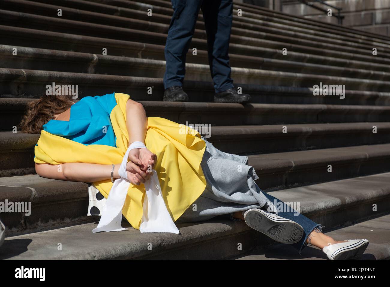 Melbourne, Australia. 10th Apr, 2022. A pro-Ukrainian demonstrator lies on the steps of Parliament House in Melbourne in response to Russian soldiers killing Ukrainian civilians. Credit: Jay Kogler/Alamy Live News Stock Photo