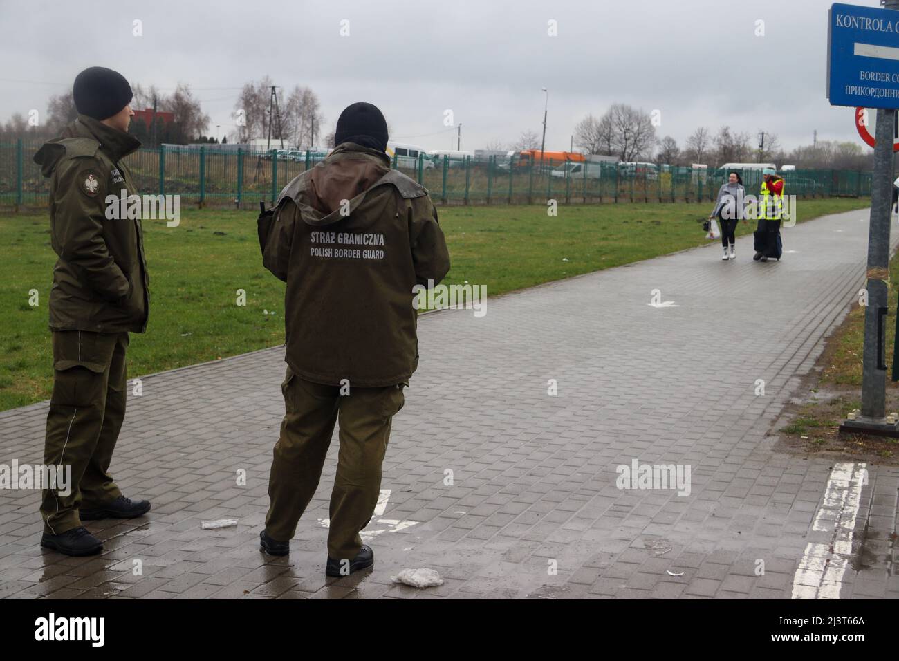 Medyka, Poland. 8th Apr, 2022. Polish Border Guards at the Polish/Ukraine border in background; they watch as a refugee makes her way to their gate in Medyka border Crossing (Credit Image: © Amy Katz/ZUMA Press Wire) Stock Photo