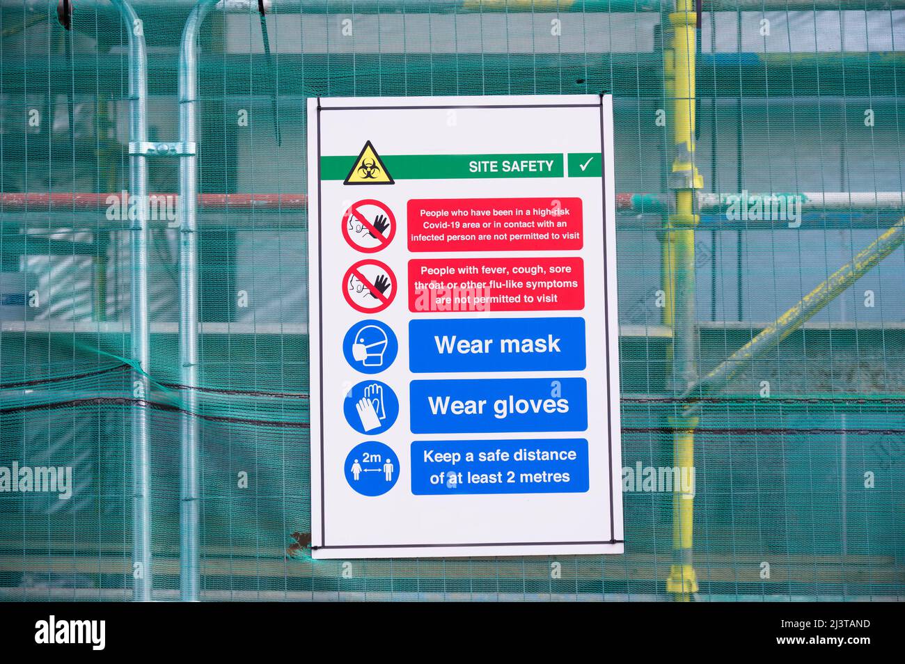 Construction site health and safety message rules sign board signage on fence boundary Stock