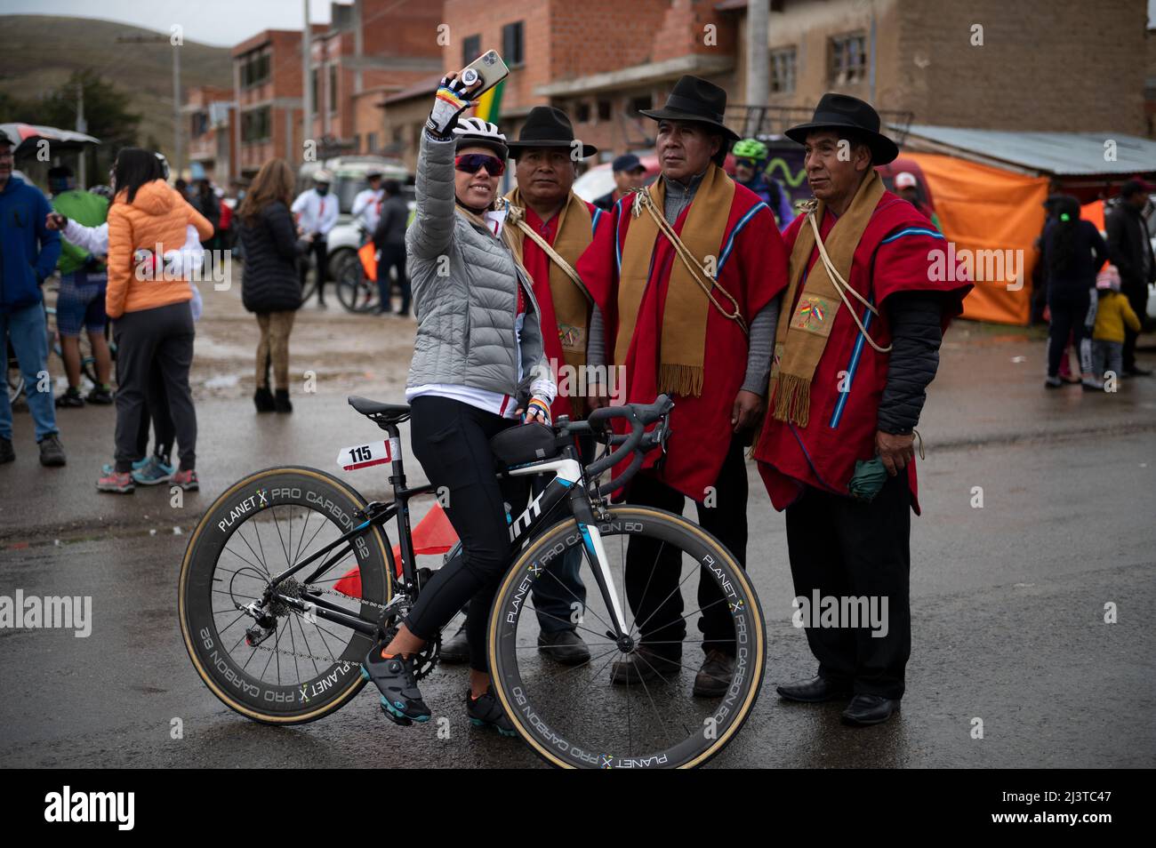 Jankho Amaya, Bolivia. 09th Apr, 2022. A cyclist takes a selfie with local authorities before the bike race. The 'Poncho rojo' (red poncho) race attracts both professional and amateur participants and runs along the shores of Lake Titicaca at altitudes ranging from 3800 to 4000 meters. This year, over 450 cyclists of all ages have registered for the event, which is either 52 or 97 kilometers long. Credit: Radoslaw Czajkowski/dpa/Alamy Live News Stock Photo