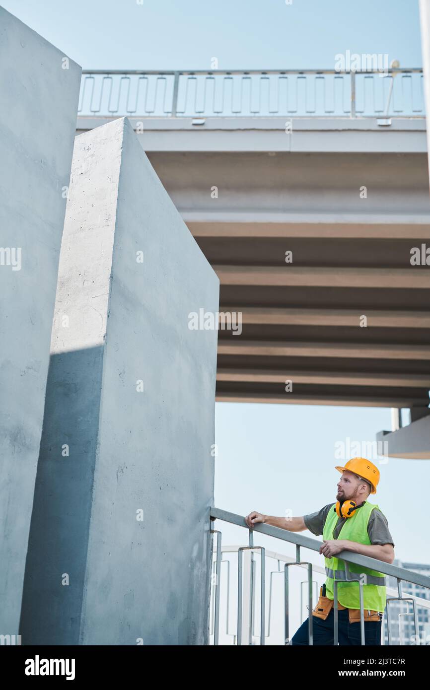 Wide angle shot of construction site with crew workers holding plans and discussing project, copy space Stock Photo