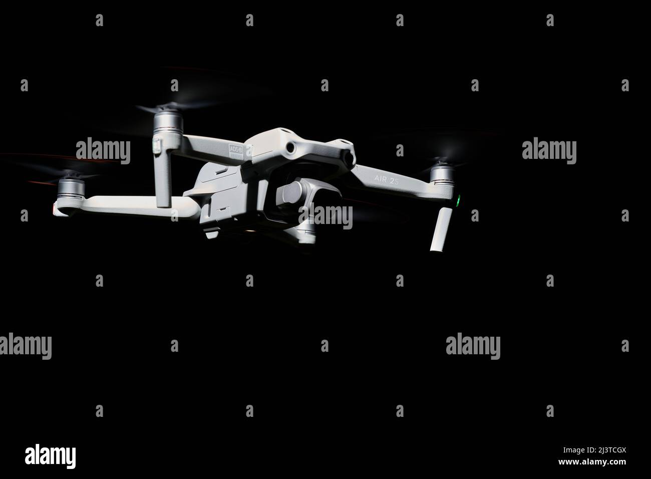 Nürtingen, Germany - June 26, 2021: Drone dji air 2s. Isolated on black. Illuminated with 1 flash at night. Side view. Copy space. Stock Photo