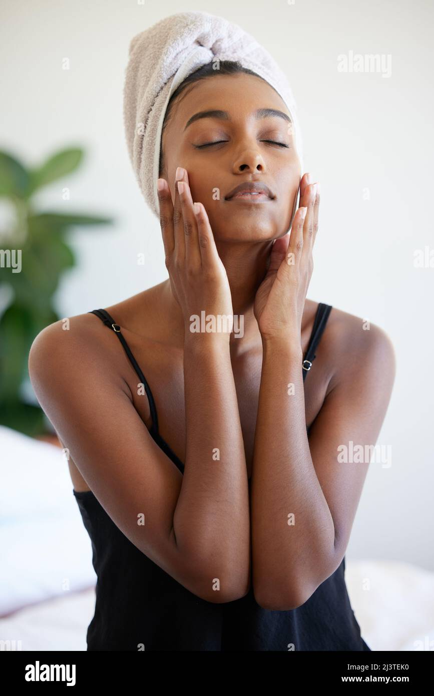 My skin never felt this good. Shot of a beautiful young woman applying
