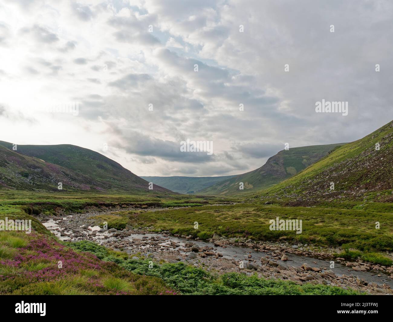 Looking down the Valley of Glen Lethnot with the Waters of Saugh gently meandering down the flat Valley Floor under the building dark clouds. Stock Photo