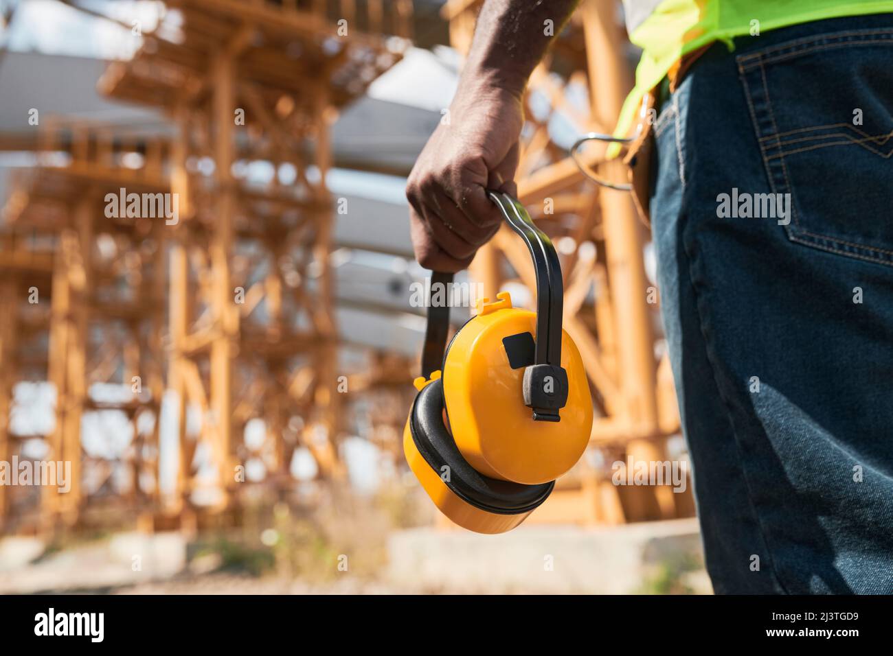 Professional engineers in workwear standing at construction site and discussing building process Stock Photo