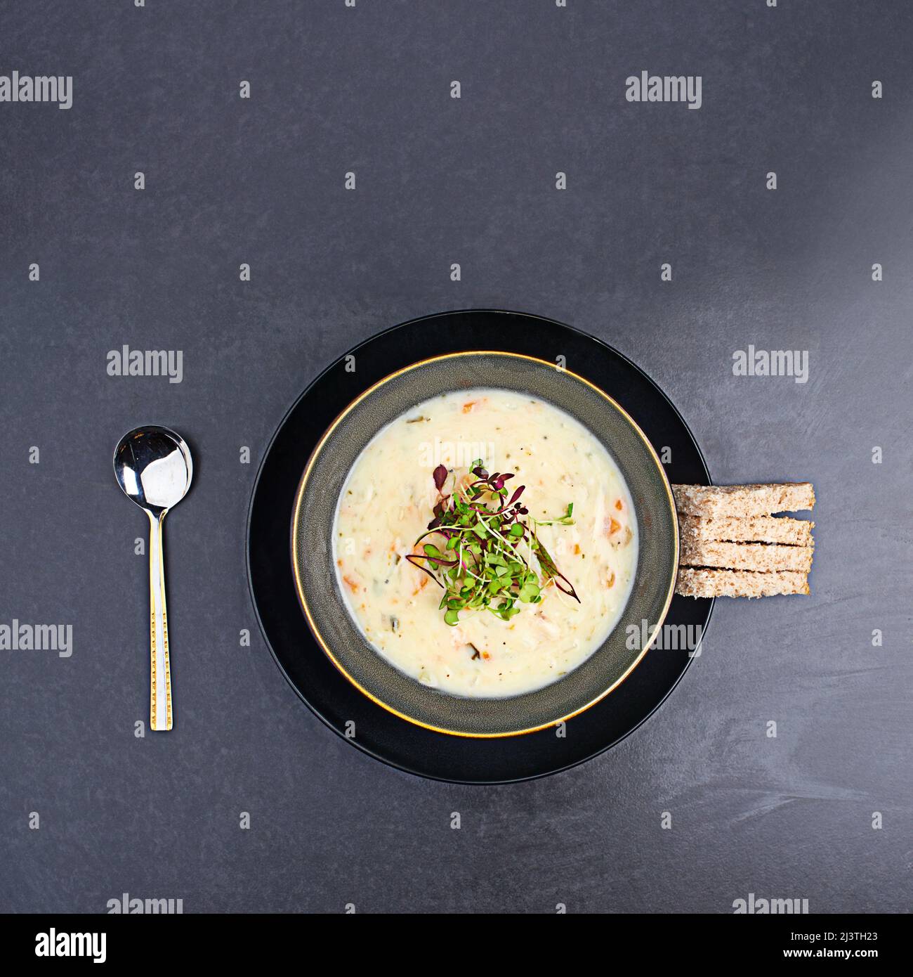 Scrumptious soup. High angle studio shot of delicious soup and bread sticks on a table. Stock Photo