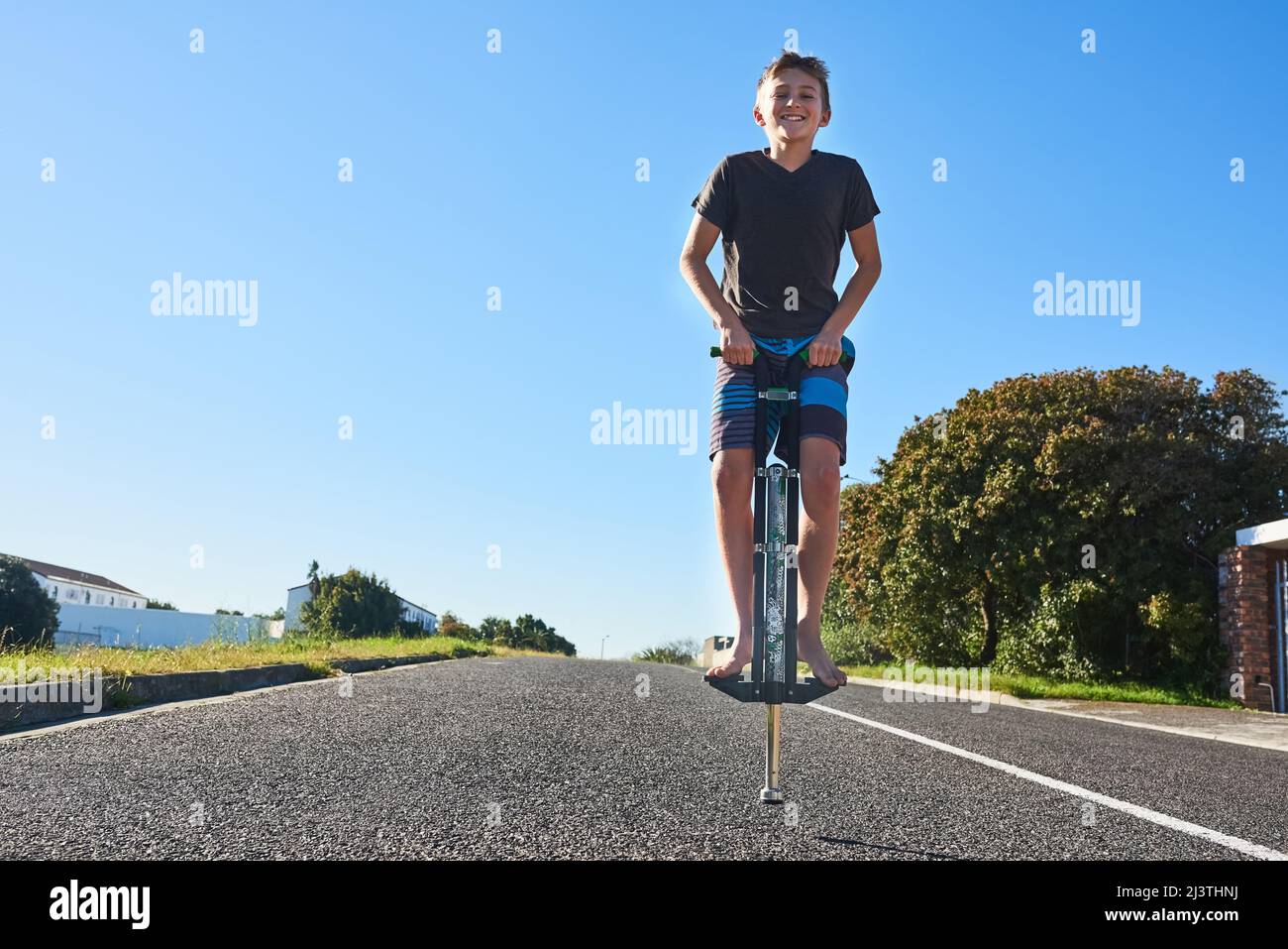 Lets bounce. Full length portrait of a young boy bouncing on a pogo stick outside. Stock Photo