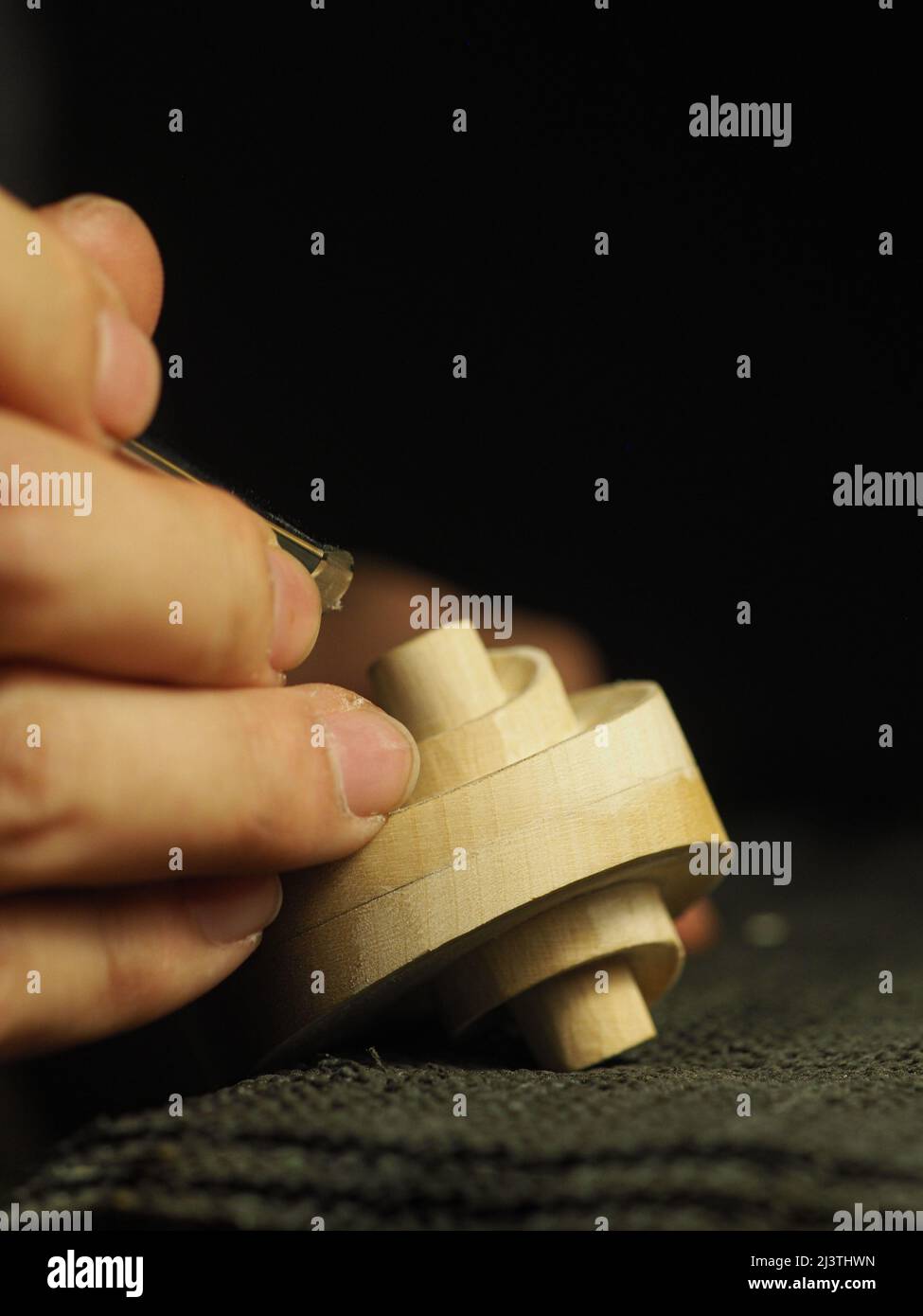 artisan sculpting a violin scroll - luthier at work concept Stock Photo