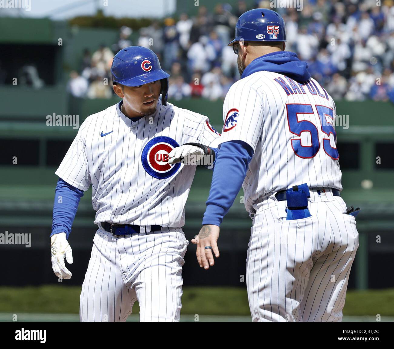 The Chicago Cubs' Seiya Suzuki (L) is congratulated by first base coach  Mike Napoli after hitting an RBI single in the third inning of a baseball  game against the Milwaukee Brewers on