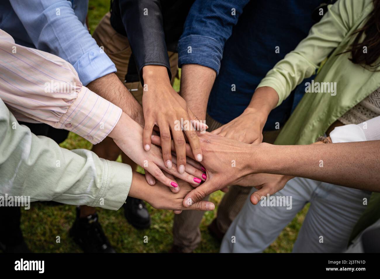 Multicultural young people joining hands in stack - unity and collaboration concept Stock Photo