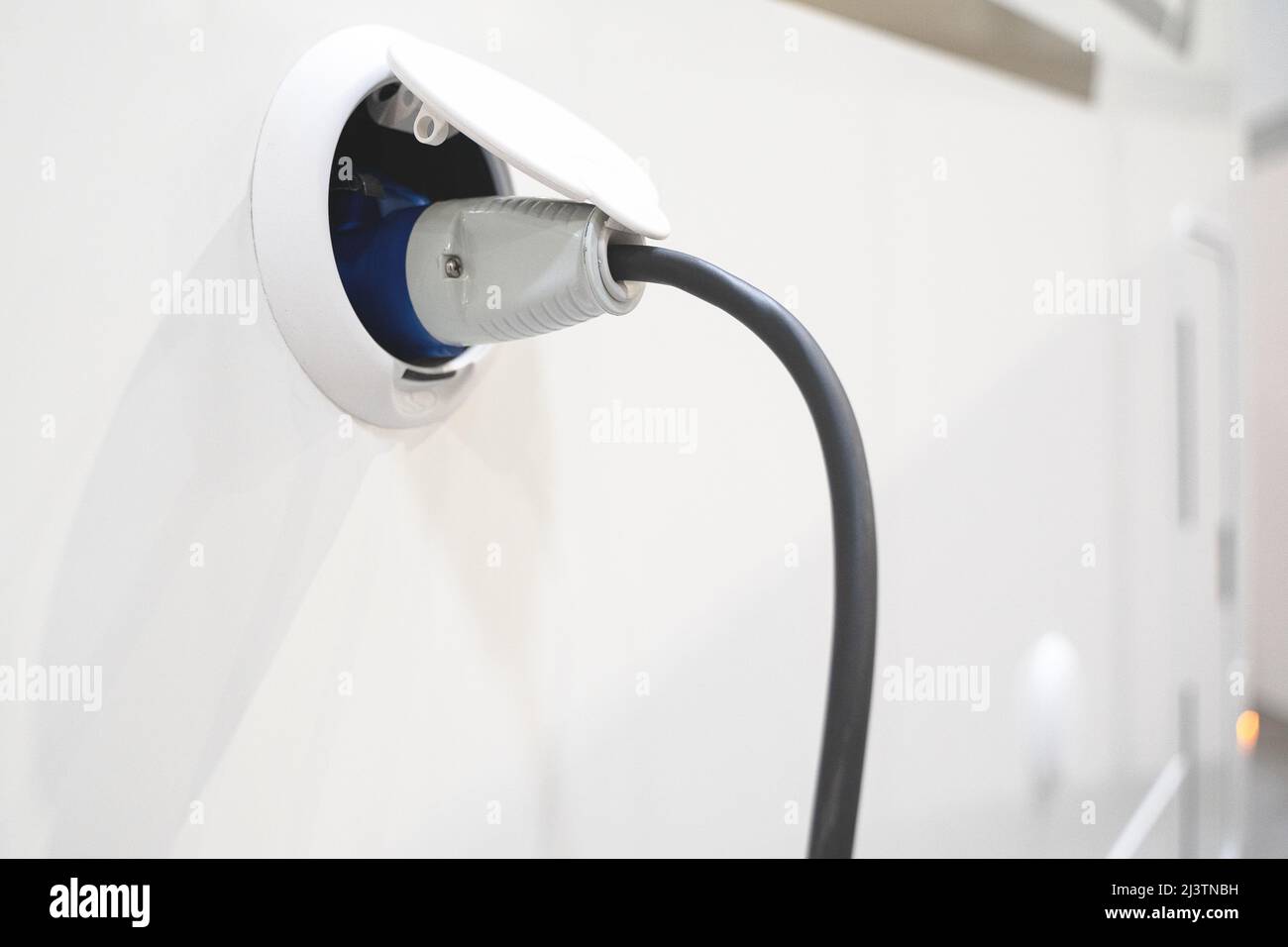 perspective view closeup of motorhome electricity outlet plug attached to  stationary white RV travel campervan Stock Photo - Alamy