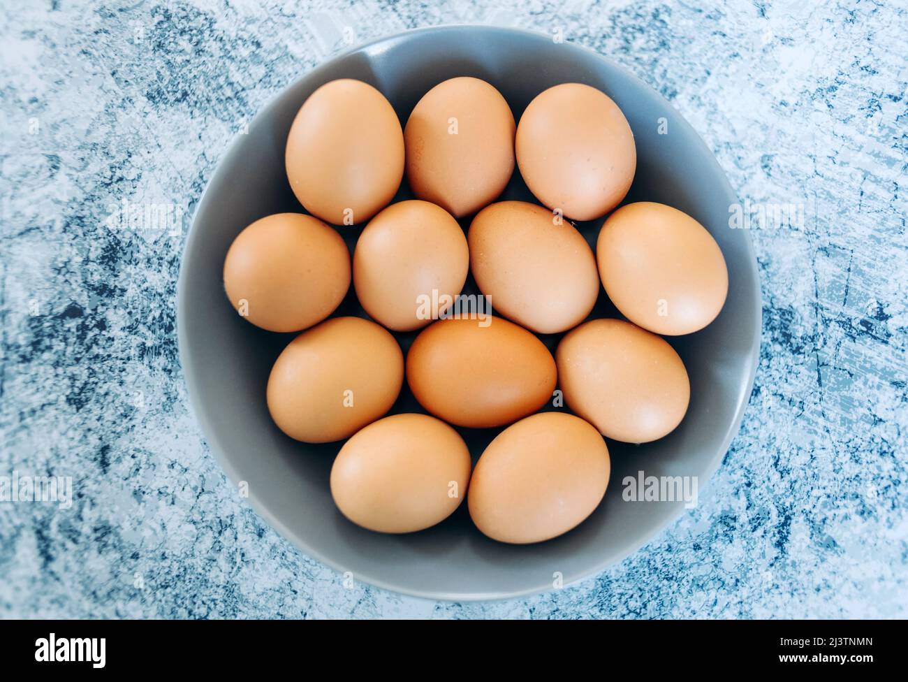 White eggs on a grey plate and a blue background Stock Photo