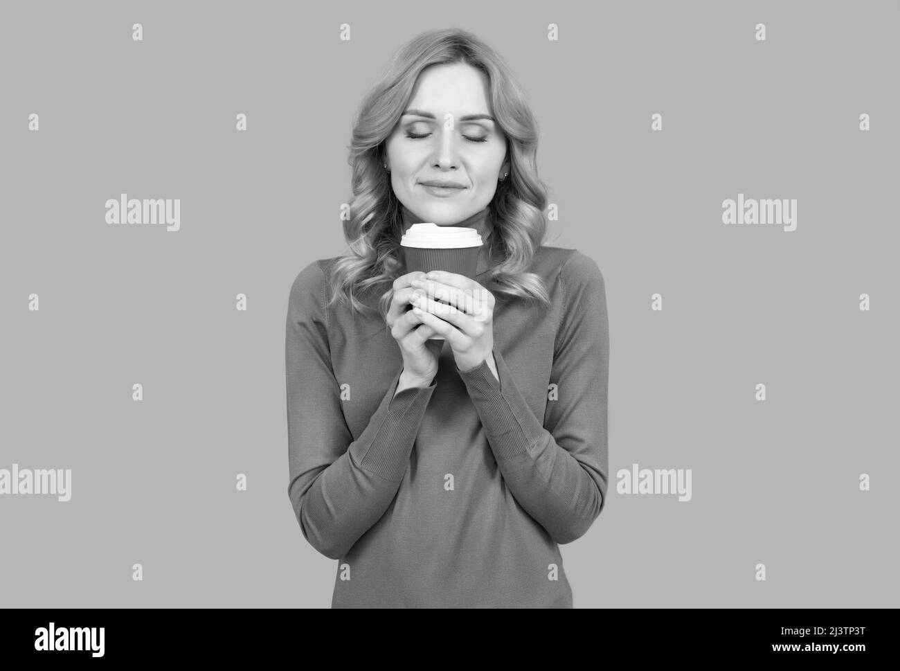 Pretty woman with closed eyes enjoy aroma of fresh brewed tea or coffee, enjoying life Stock Photo