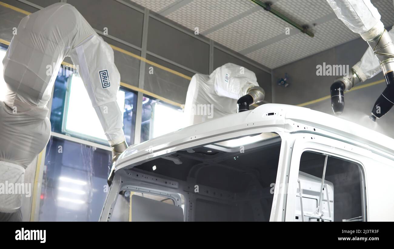 Robotic technology paints body of car. Scene. Robotic hands paint car