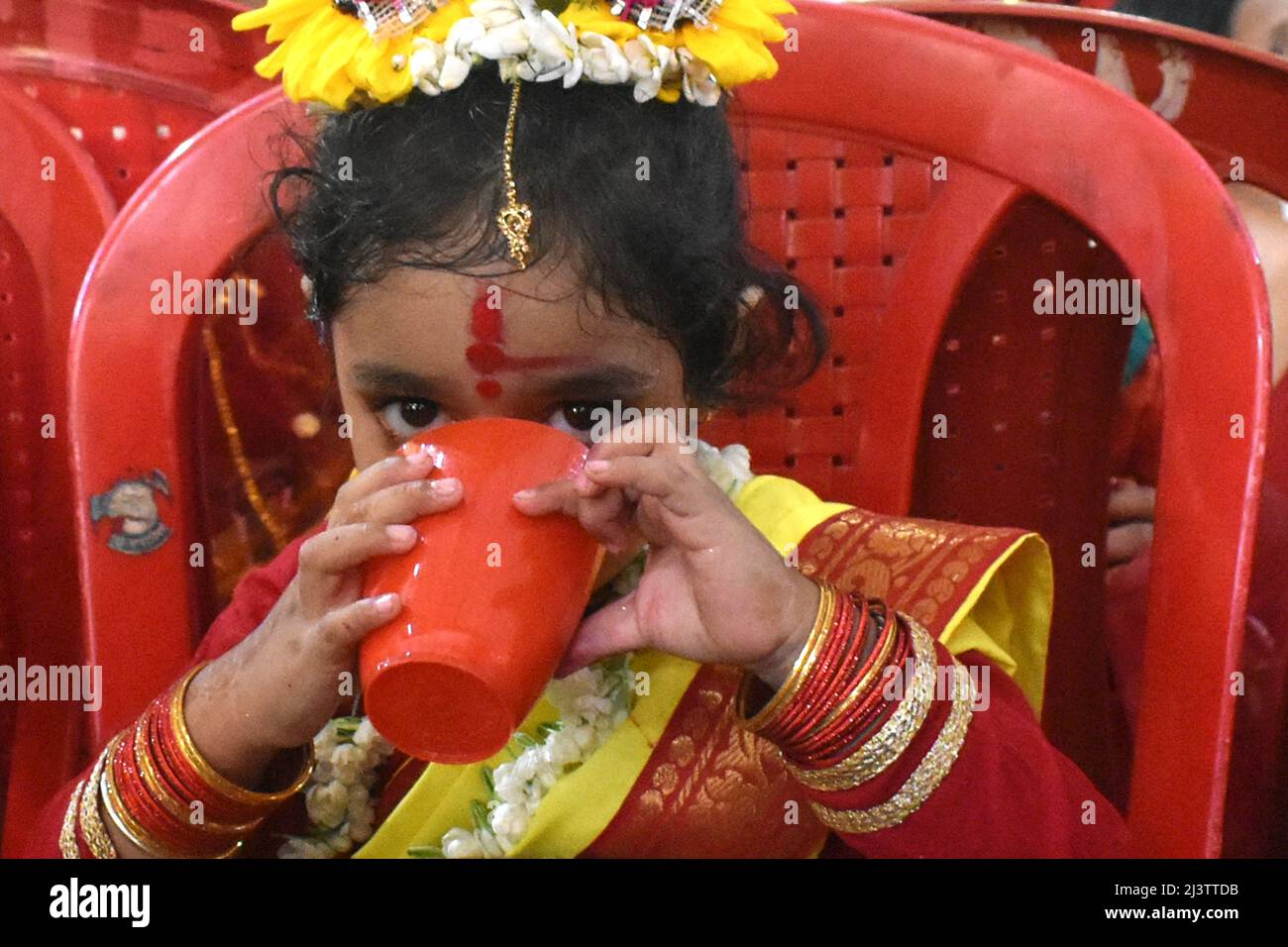 Kolkata, India. 10th Apr, 2022. A girl dressed as Kumari drinking water