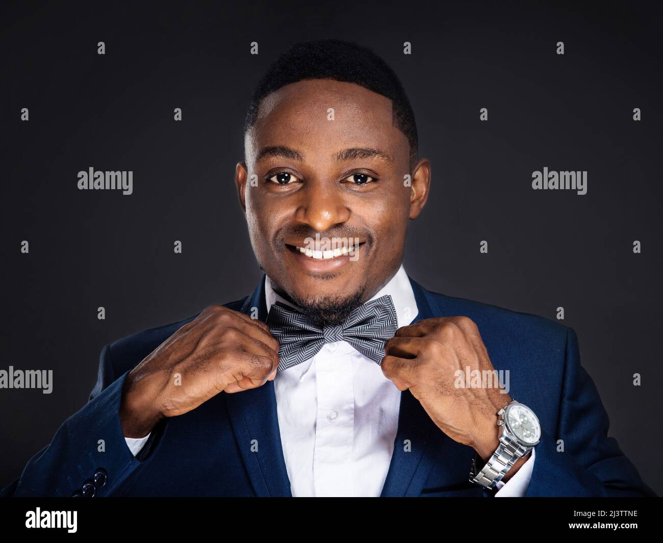Handsome african american stylish man with bow tie on black background ...