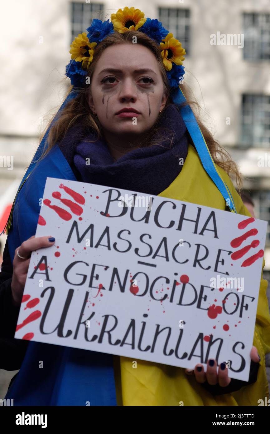 London, UK. 9th Apr, 2022. Hundreds of Ukrainians simulate their deaths in a die in with hands tied behind their backs and Women paint blood on their faces to protest the ongoing Russian invasion of Ukraine opposite Downing Street. Stock Photo