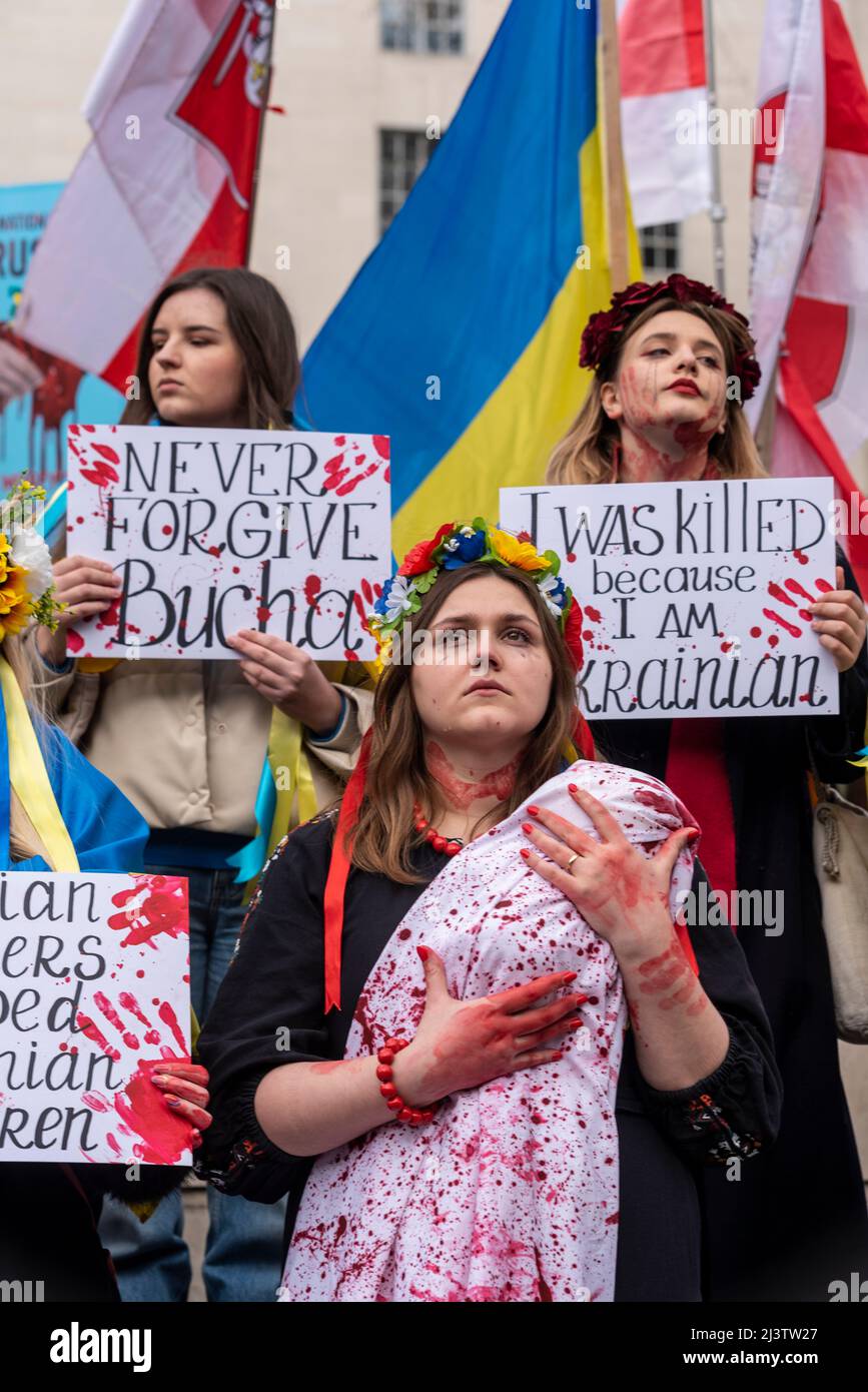 Protesters carrying out a die-in, referencing the killed Ukraine civilians in towns such as Bucha during war with Russia. Females with 'dead' baby Stock Photo
