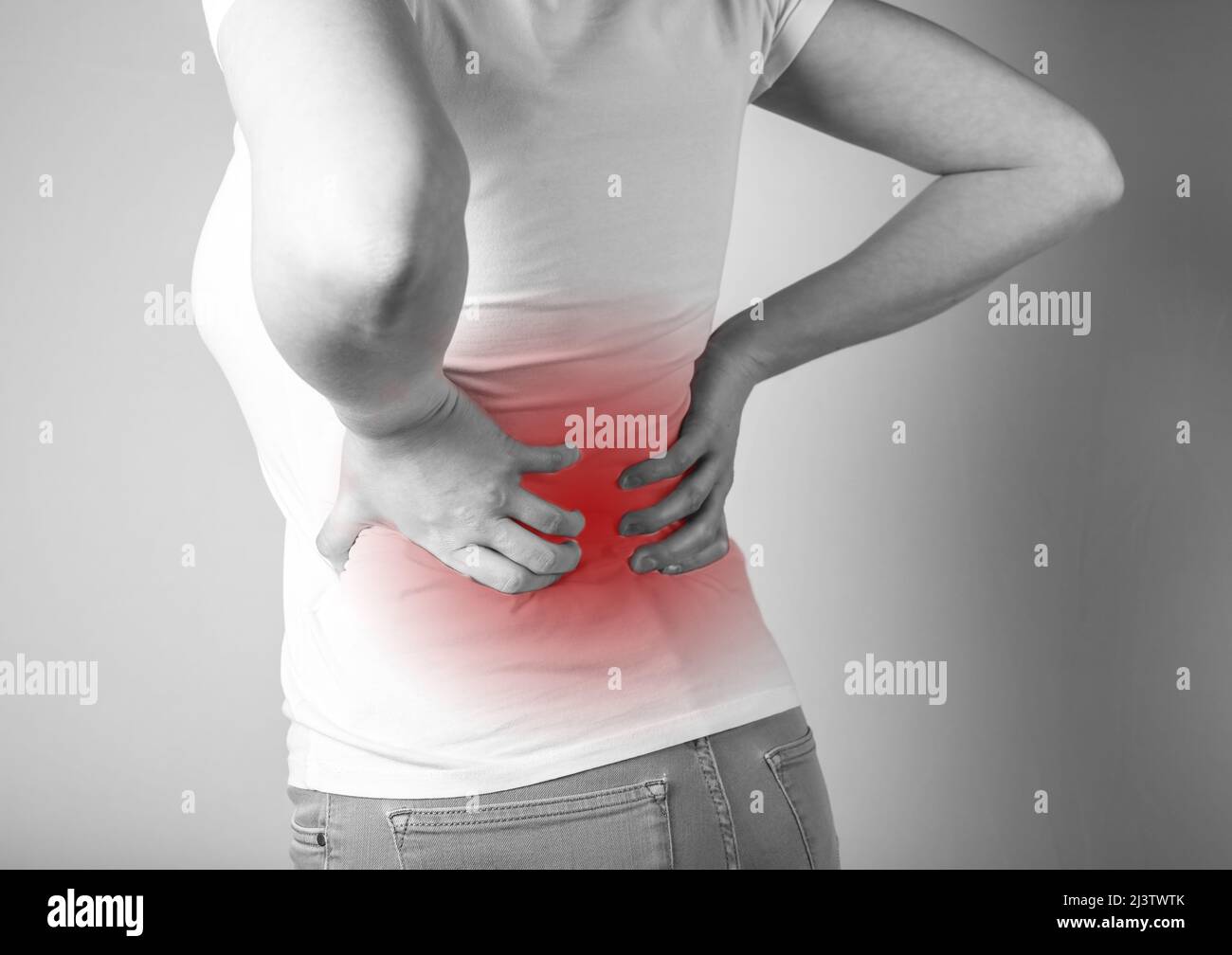 Lower back pain. Woman suffering from backache with red spot closeup