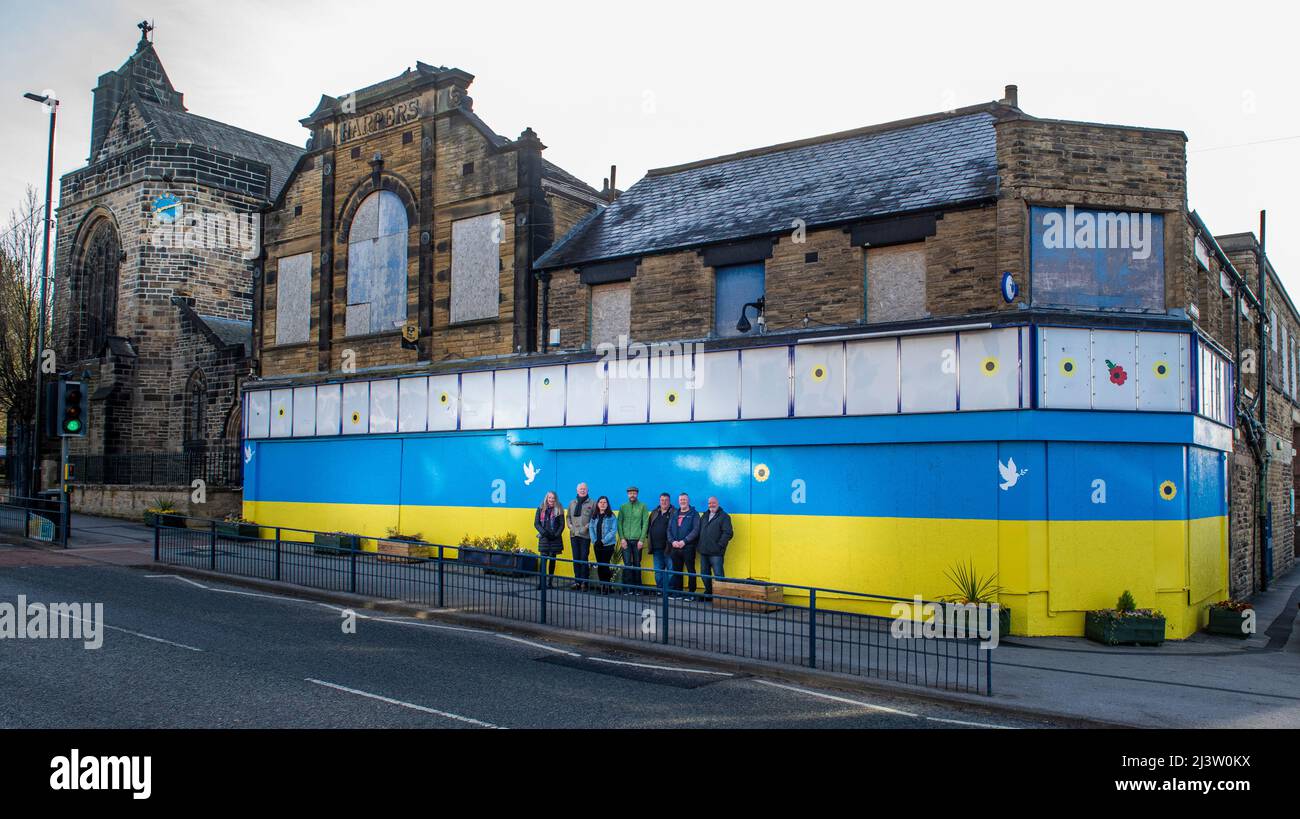 Starbeck, Harrogate, UK. 10th Apr, 2022. Members of Starbeck Community Group Jill De Witt, Andrew Hart, Lucky Hubbard, Nik Mills, John Keane, David Stead and Colin Wilson photographed in front of a 40 metres Ukrainian flag they painted over the once beautiful and now derelict Harper's building on Starbeck High Street. This is one of many projects they are working on to revitalise and motivate their local community. Credit: ernesto rogata/Alamy Live News Stock Photo
