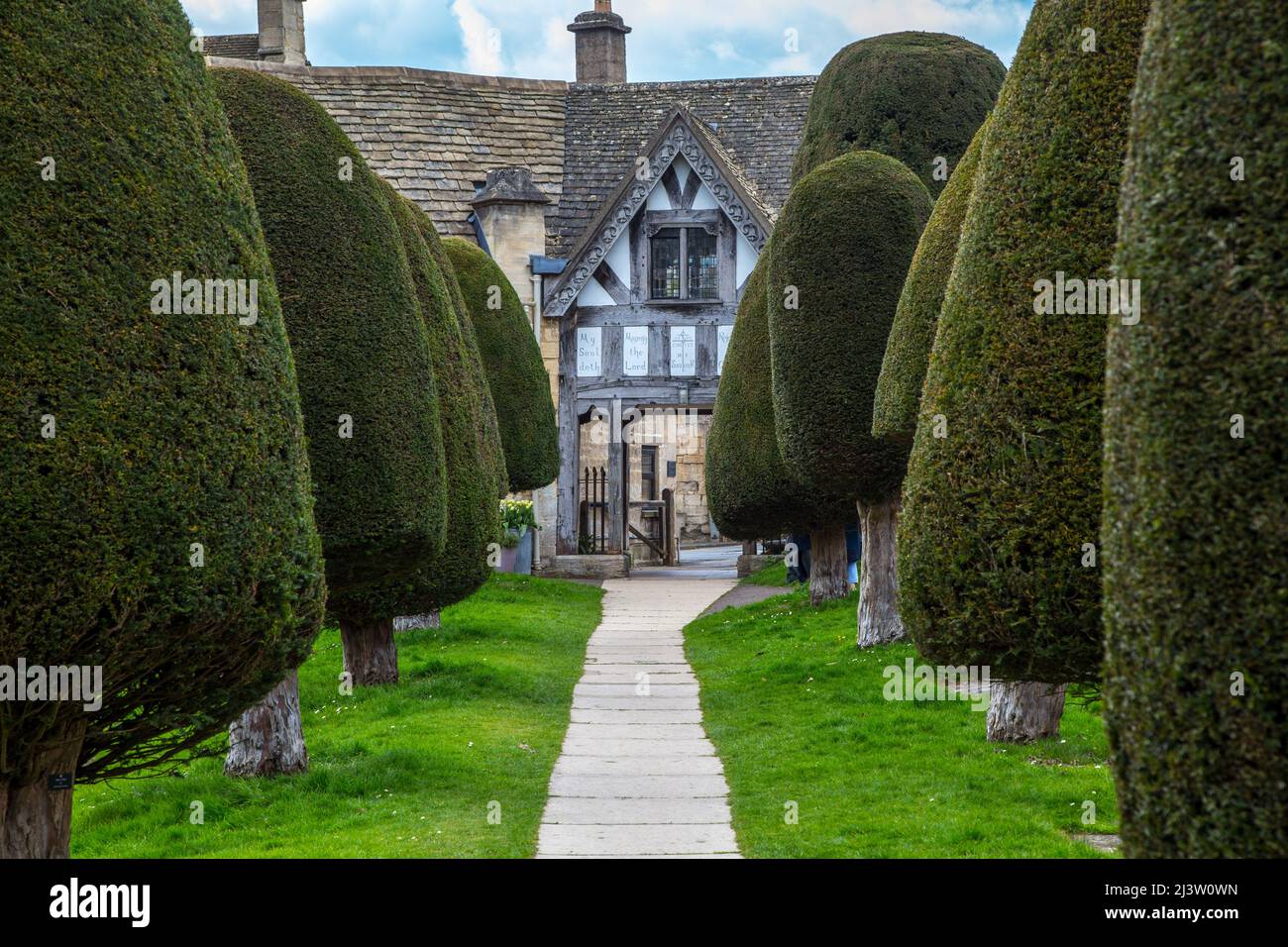 Painswick village church yard entrance and yew trees in the Cotswolds, Gloucestershire Stock Photo