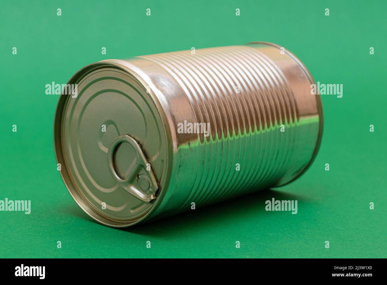 Unopened Tin Can with Blank Edge on Green Background. Canned Food