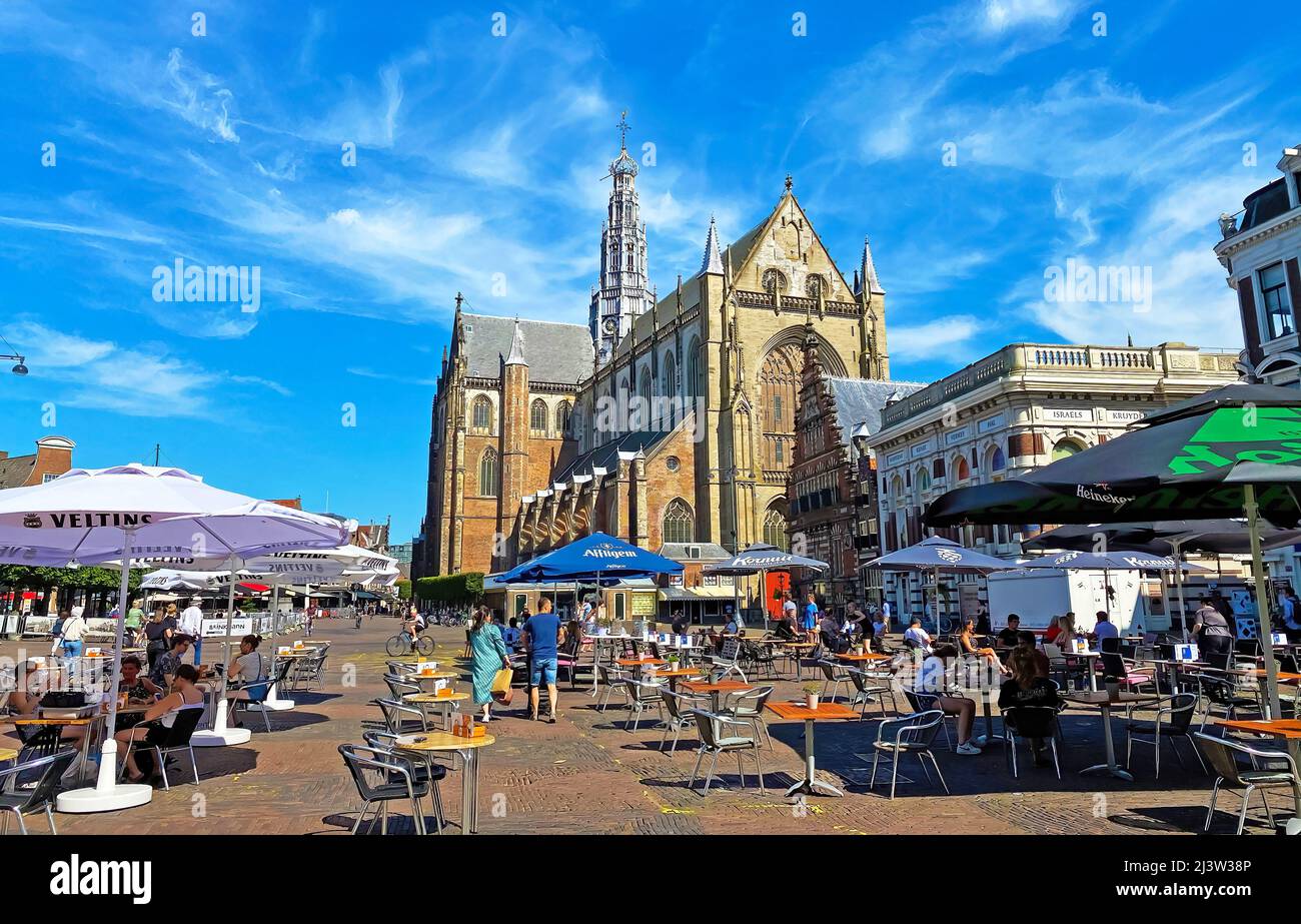 Haarlem, Netherlands - June 26. 2020: View over market square with people sitting outside cafe restaurants (grote markt) on cathedral (grote kerk or S Stock Photo