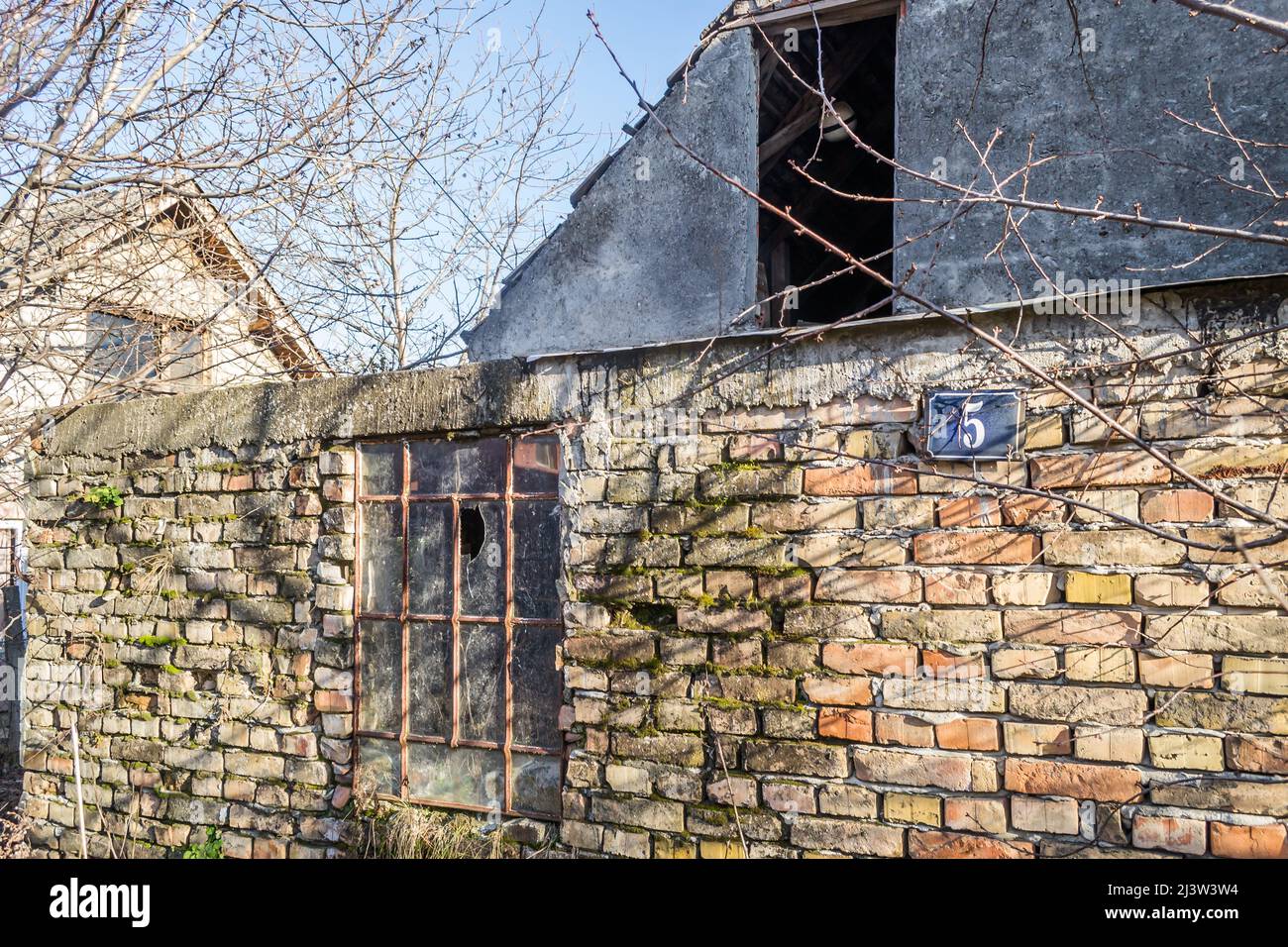 An old metal window with broken glass, on the wall of an old ...