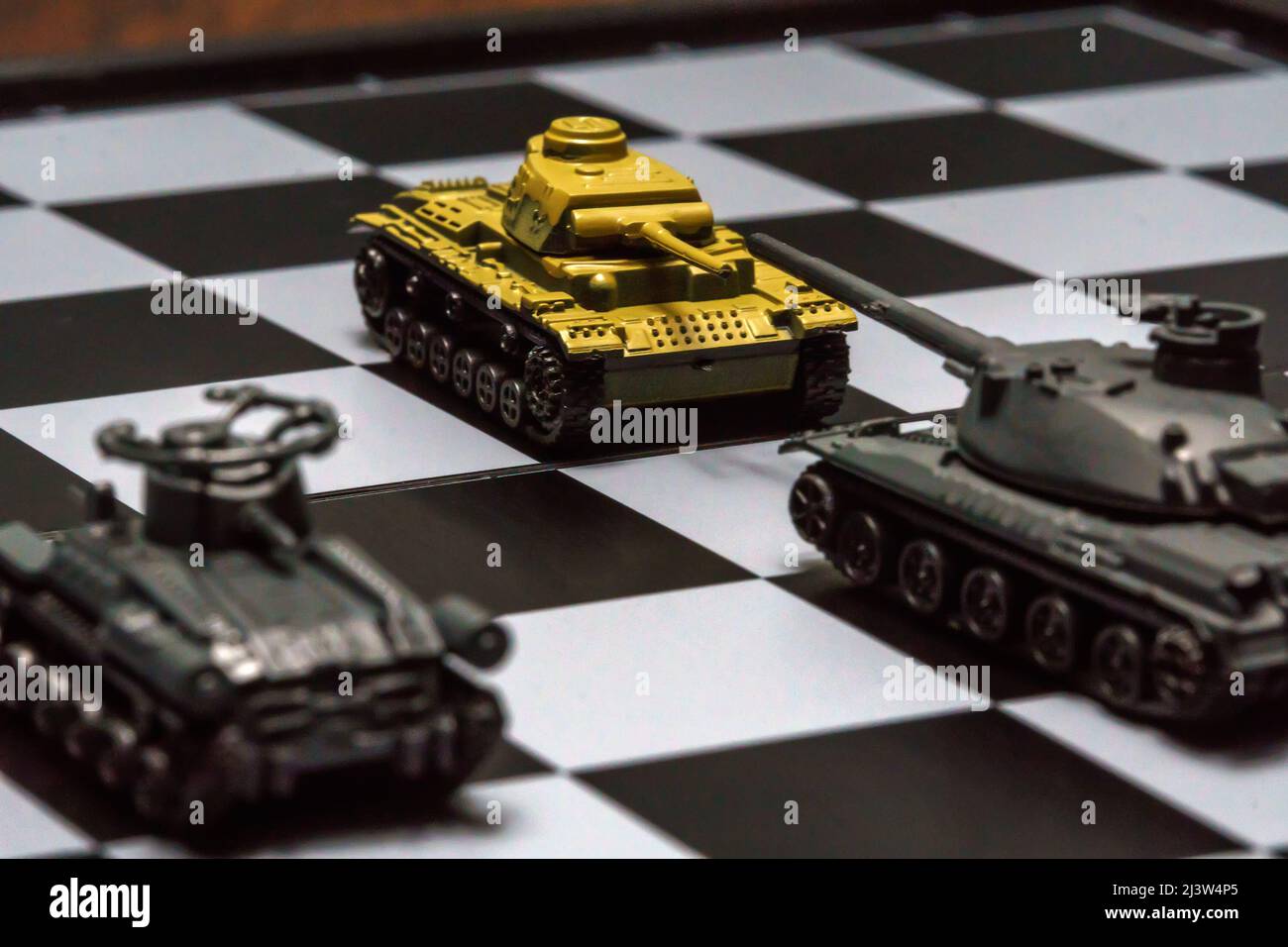 Toy tanks with chess on chessboard. Concept of military strategy., Stock  image