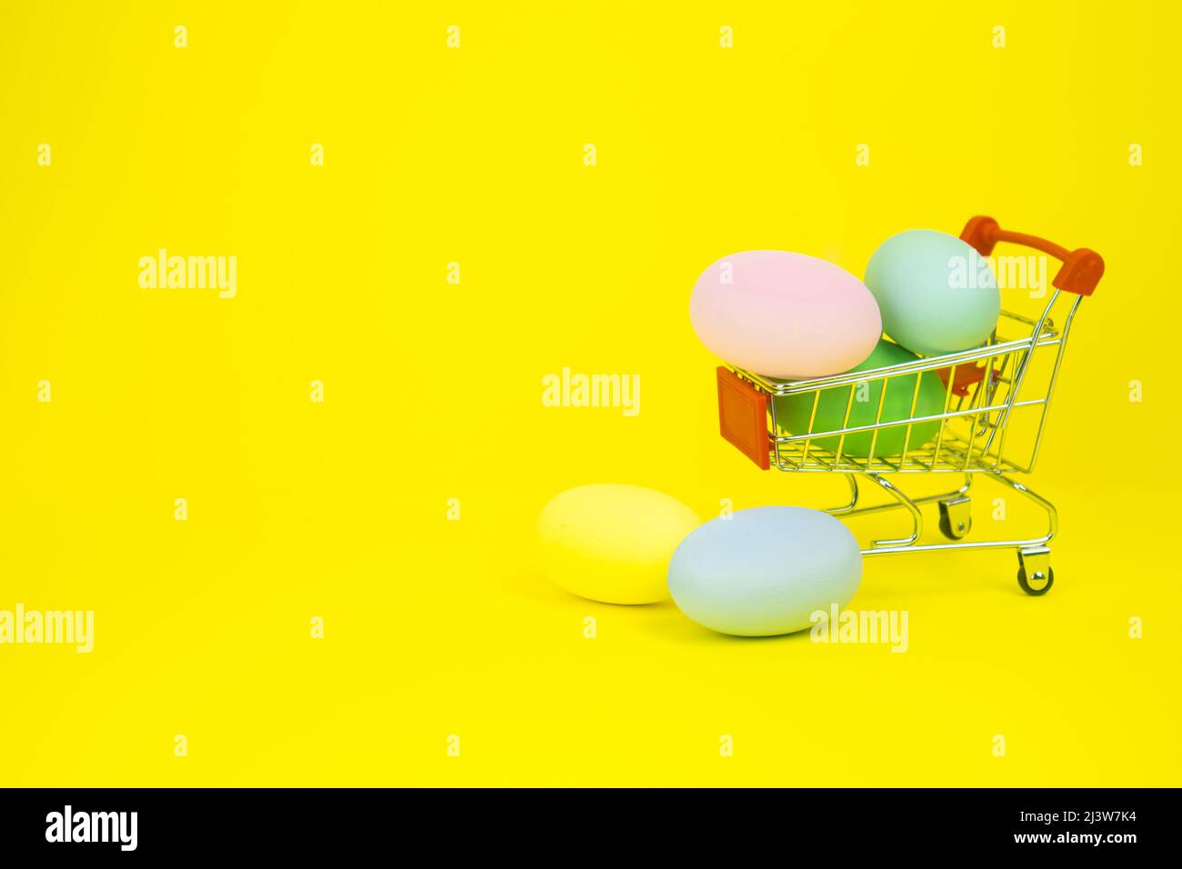 Easter . Basket with Easter eggs on a yellow background. With place for text. Stock Photo