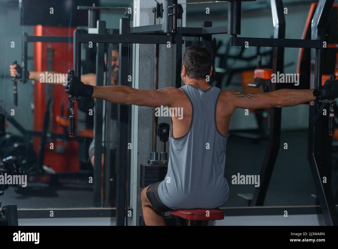 Mature trainer athlete working out chest muscles doing strength