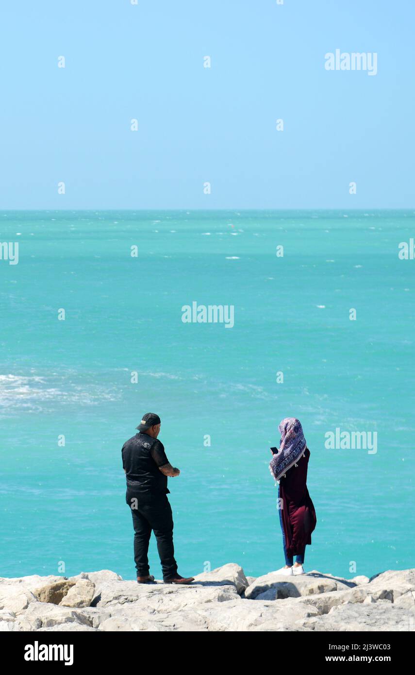 A couple enjoying the views of the Persian Gulf sea in Abu Dhabi, UAE. Stock Photo