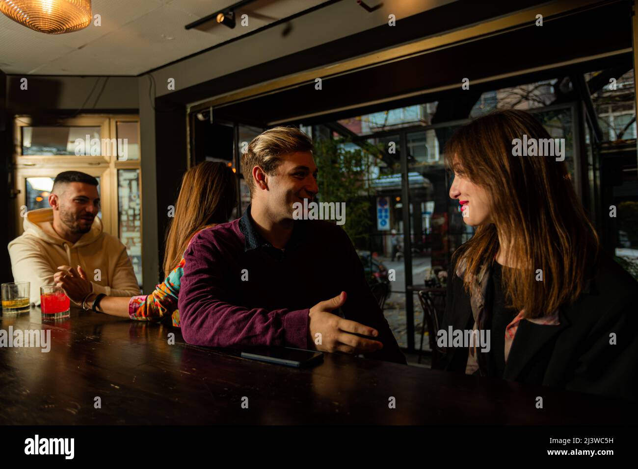 Amazing and beautiful two young couples are talking on the bar and ...