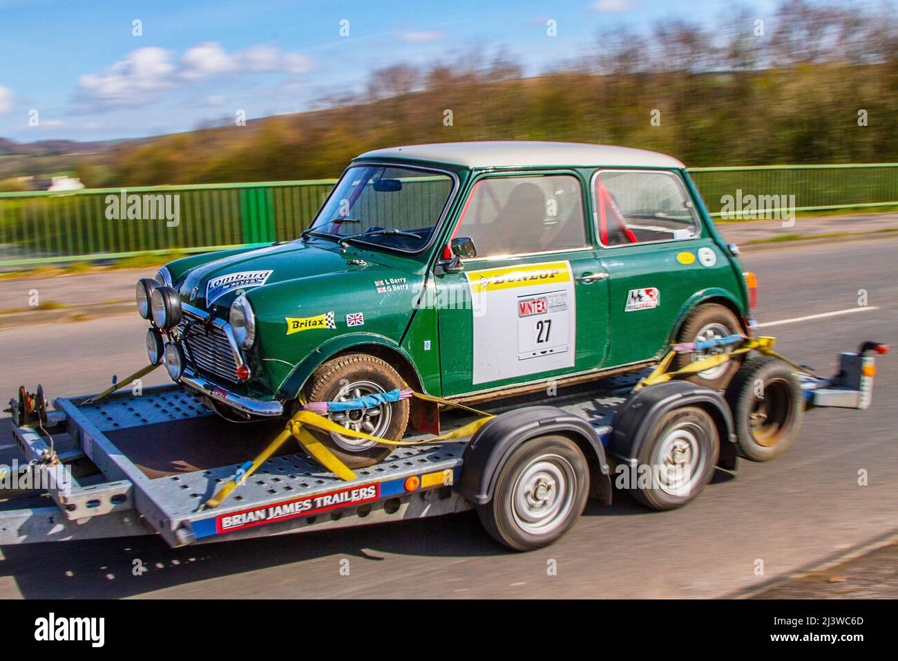 1972 70s seventies sporting green Mini 1200 Leyland Cars 1275cc petrol Rally car No.27 being carried on trailer. Stock Photo