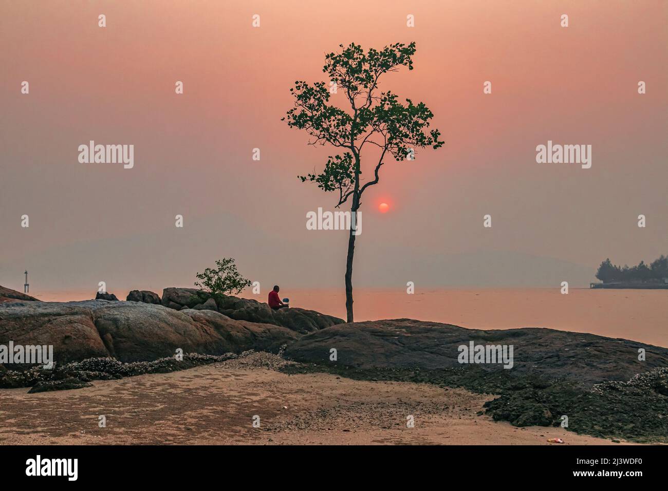 Sunset with cloudy sky at the coast of Teluk Muroh in Lumut District of Perak, Malaysia. Stock Photo