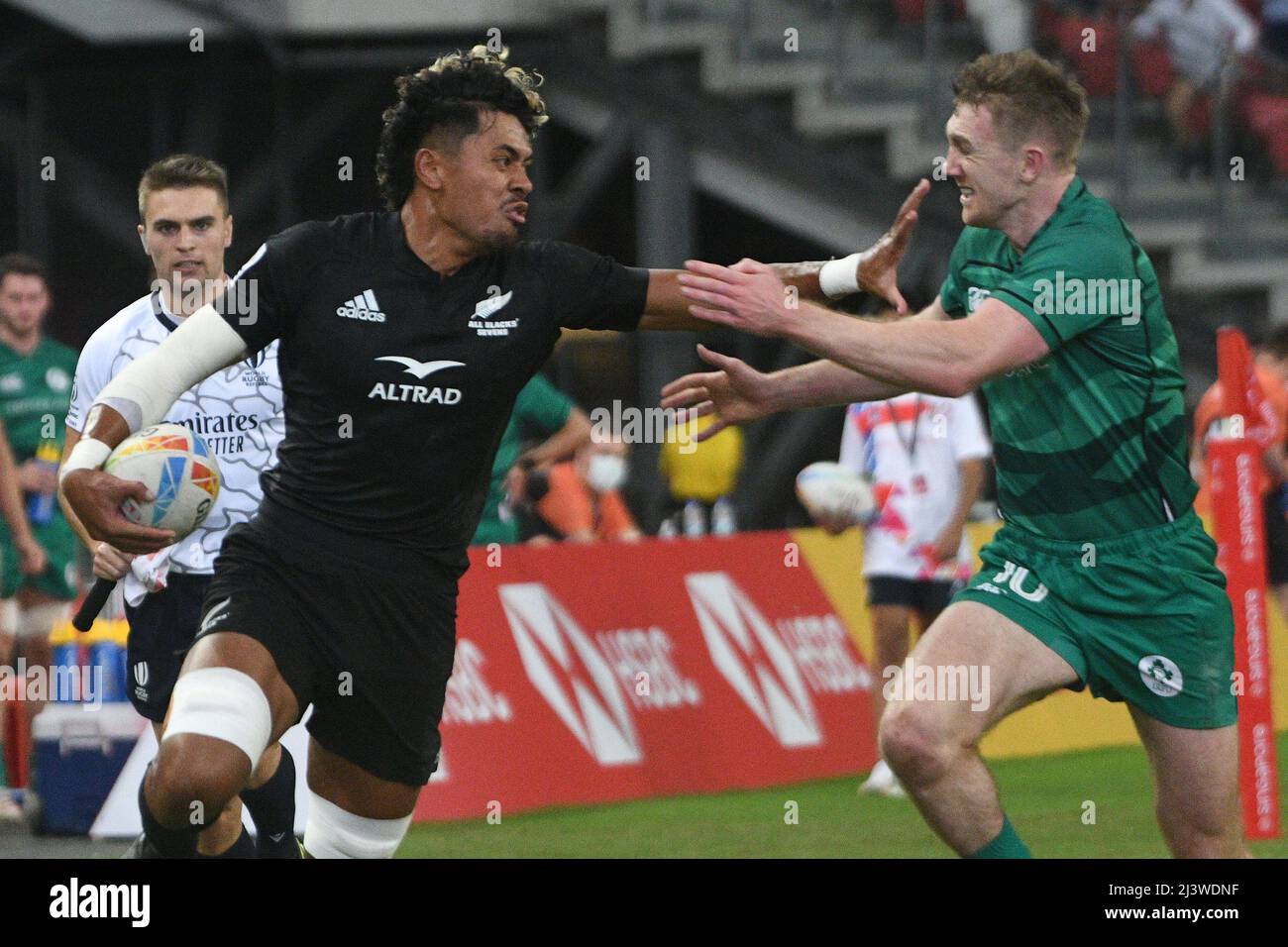 Singapore. 10th Apr, 2022. Kitiona Vai (L) of New Zealand competes during the semifinal between Ireland and New Zealand at the HSBC World Rugby Sevens Singapore stop, held in the National Stadium on April 10, 2022. Credit: Then Chih Wey/Xinhua/Alamy Live News Stock Photo