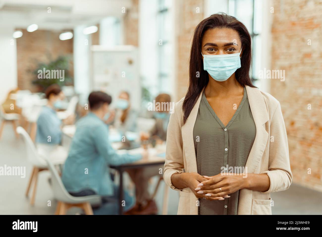 Lady wearing a protective mask while working in the office Stock Photo
