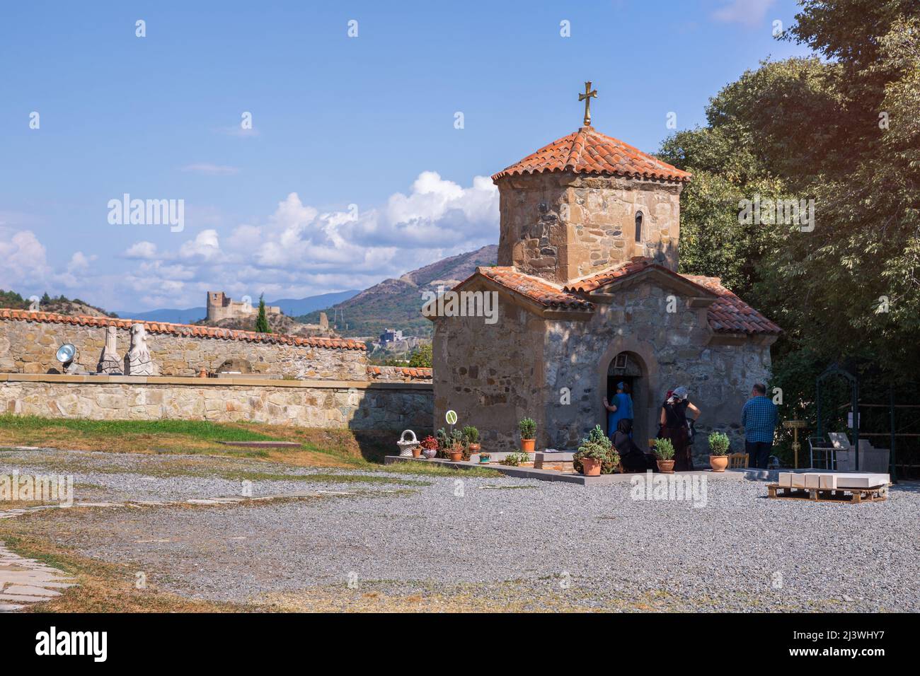 Mtskheta, Georgia - September 23, 2018: The ancient church of St. Nino in Samtavro monastery. Bebris tsikhe fortress in the background Stock Photo