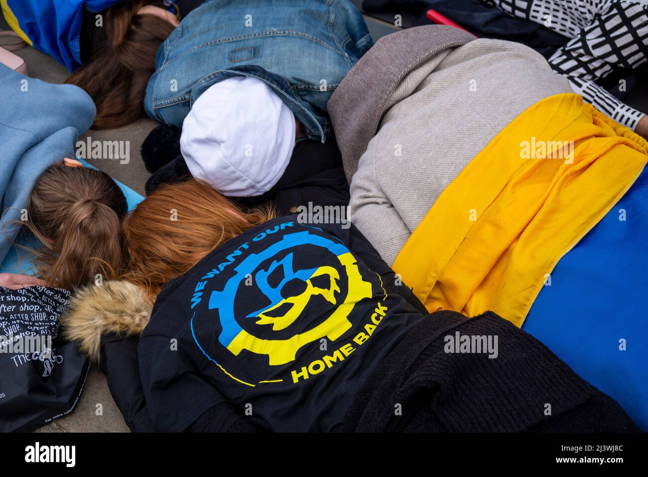 Protesters carrying out a die-in, referencing the killed Ukraine civilians in towns such as Bucha during war with Russia. Ukrainian flag Stock Photo